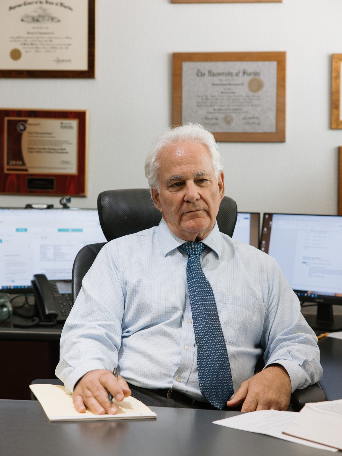 Attorney portrait at his desk with credentials on the wall — professional services photography by Orange Grove Social