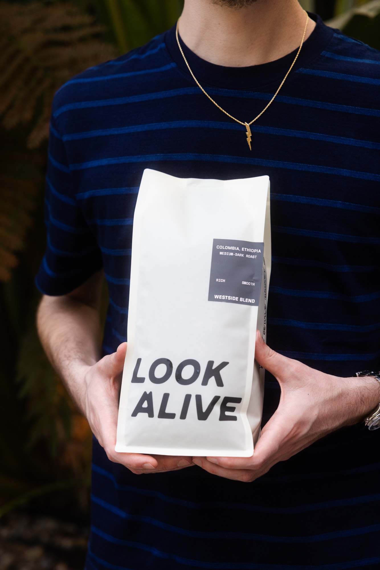 Hand holding a coffee brand bag — product packshot photography by Orange Grove Social