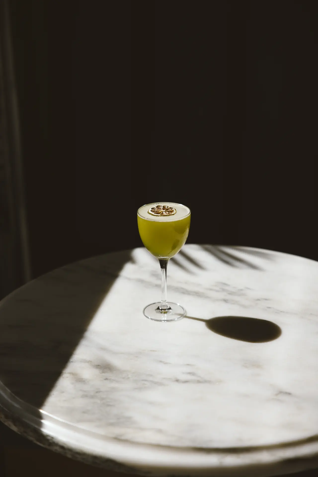 Cocktail in hard window light on a marble table at Bar Mezzo, photographed by Orange Grove Social