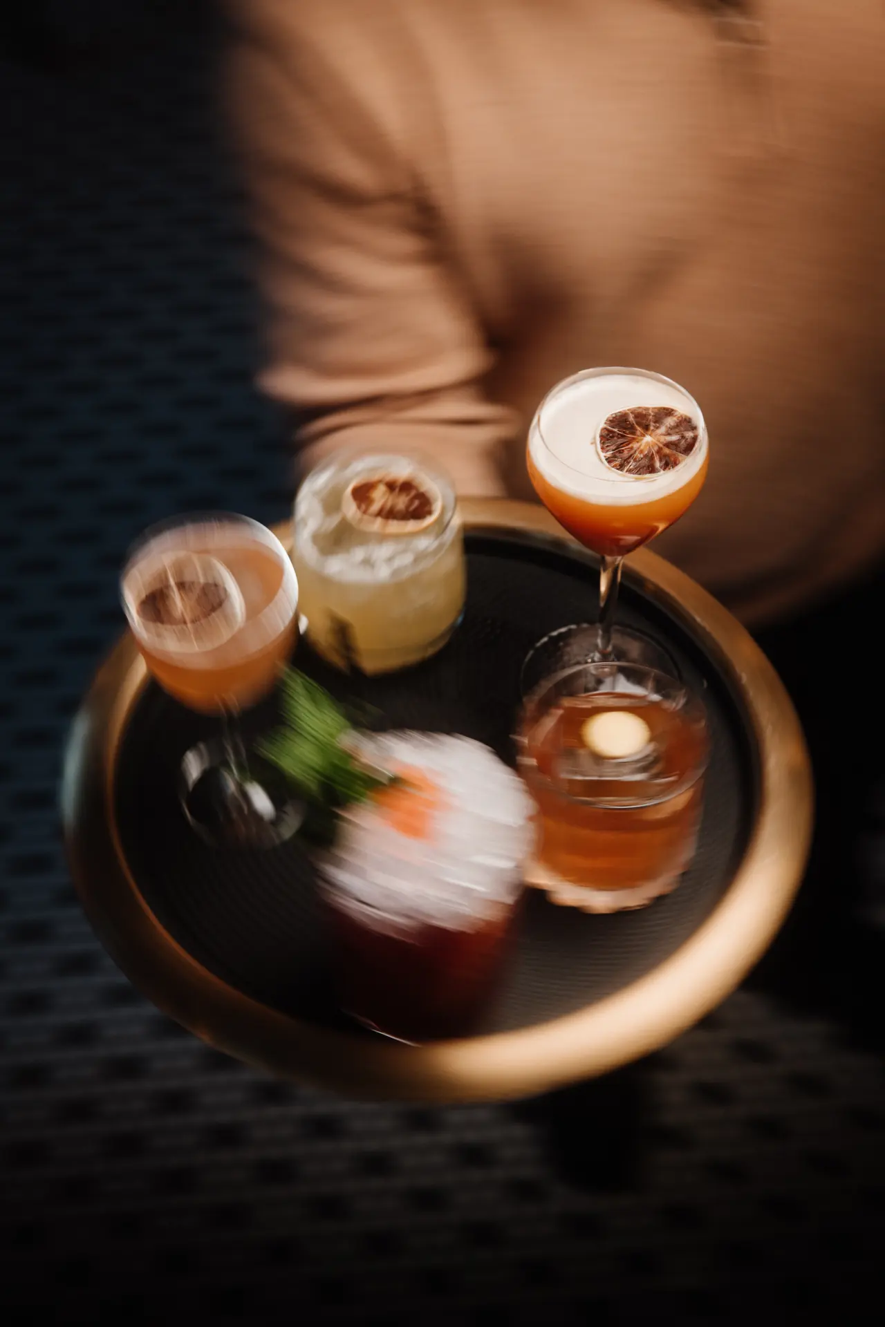 Server carrying a tray of cocktails at Bar Mezzo, photographed by Orange Grove Social