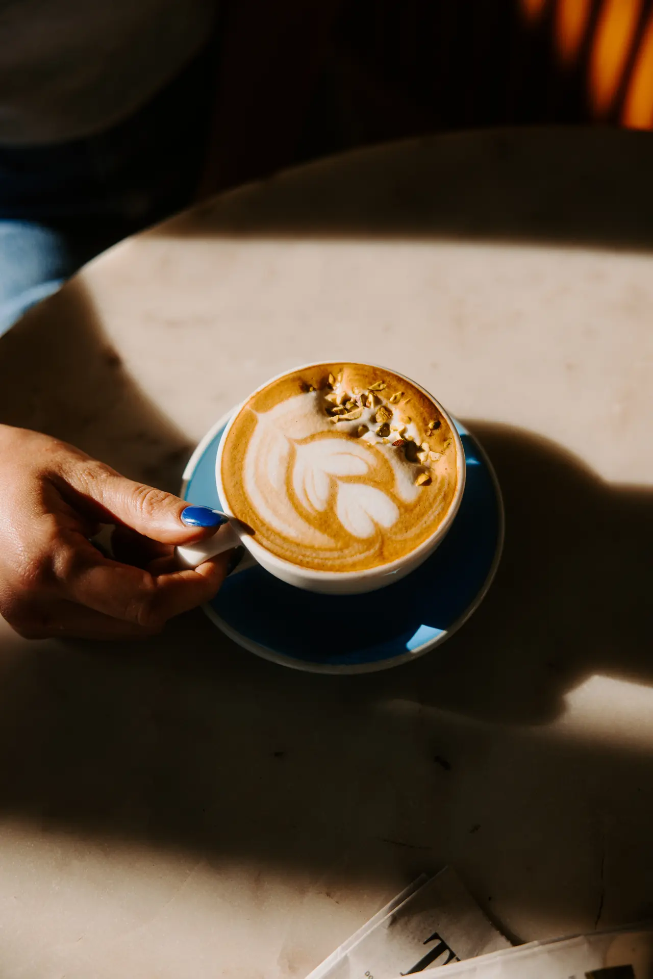 Cappuccino with latte art in a blue cup at Intermezzo, photographed by Orange Grove Social