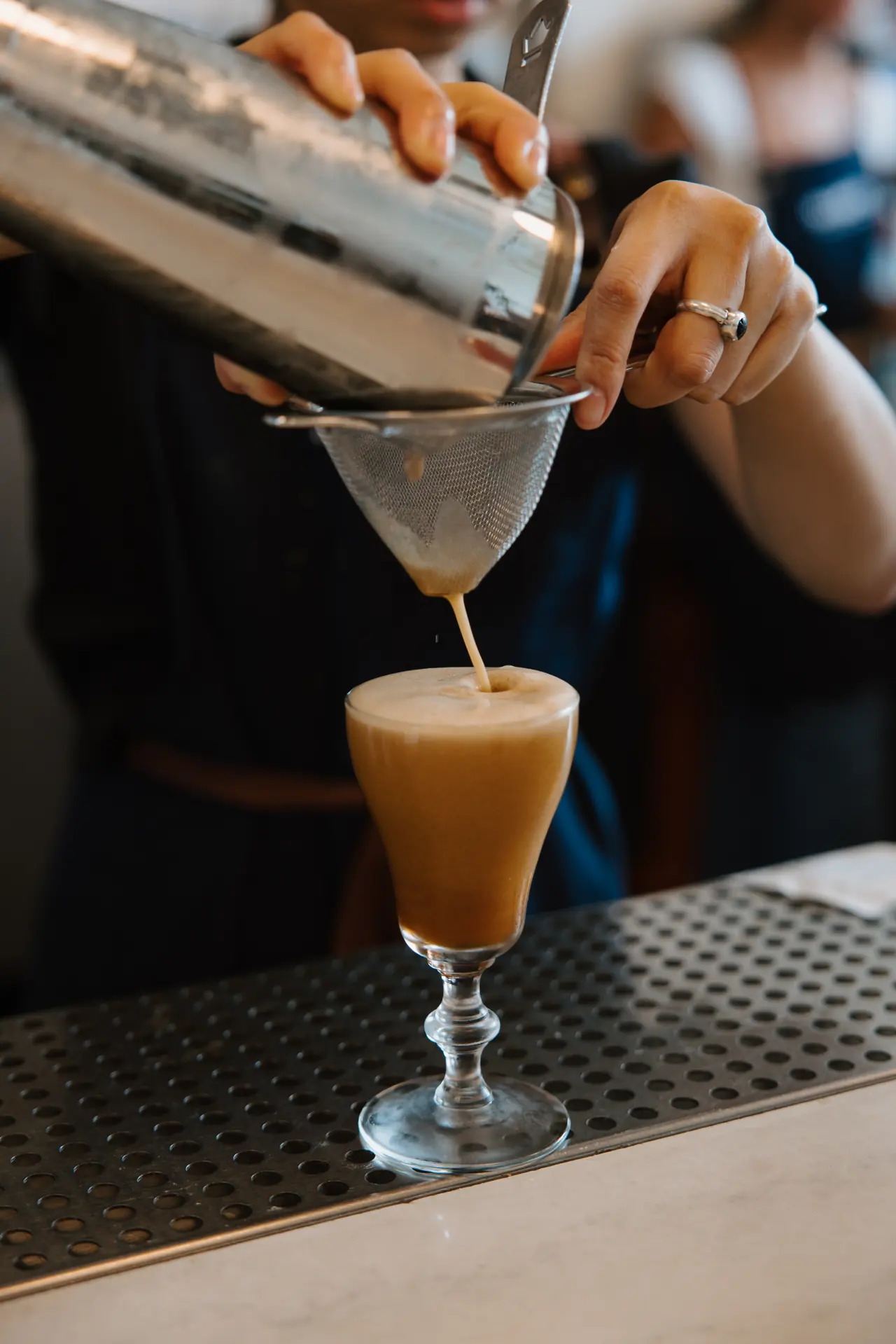 Bartender straining a cocktail at Intermezzo, photographed by Orange Grove Social