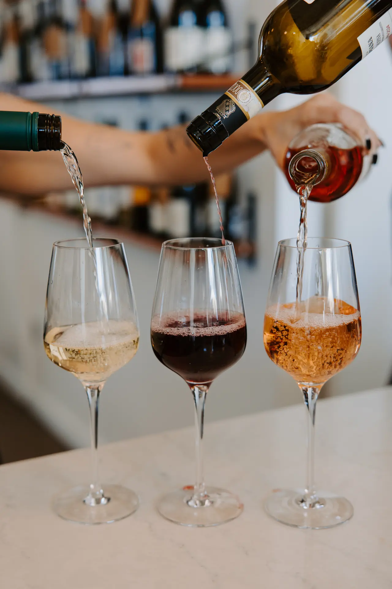 Three glasses of wine being poured at Intermezzo, photographed by Orange Grove Social