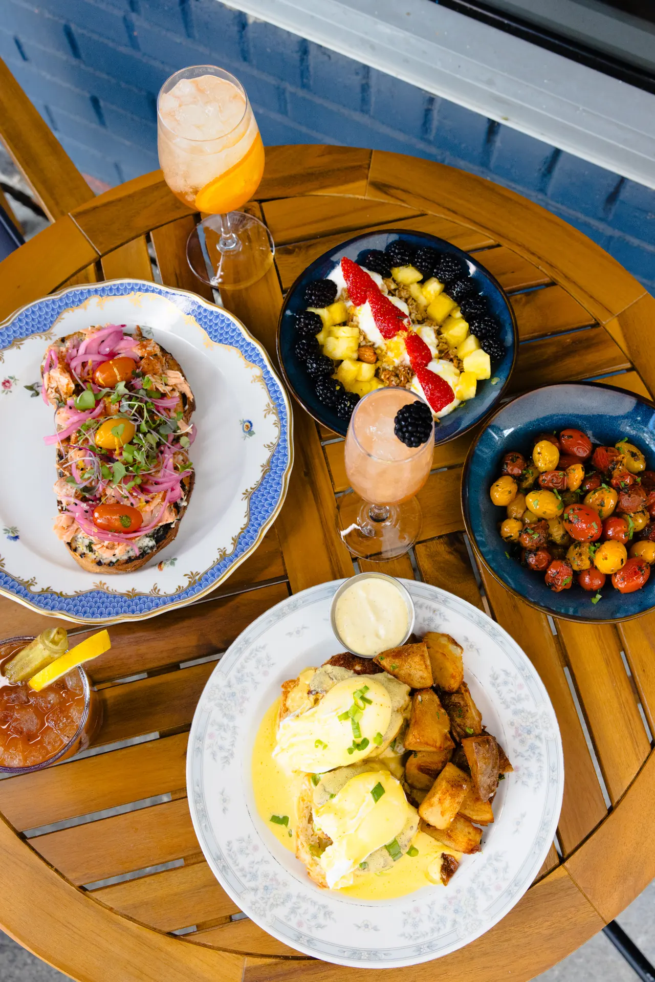 Overhead brunch spread with eggs Benedict and cocktails at The Tides Market, photographed by Orange Grove Social
